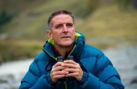 Naturalist and Springwatch presenter, Iolo Williams posing with his binoculars in hand